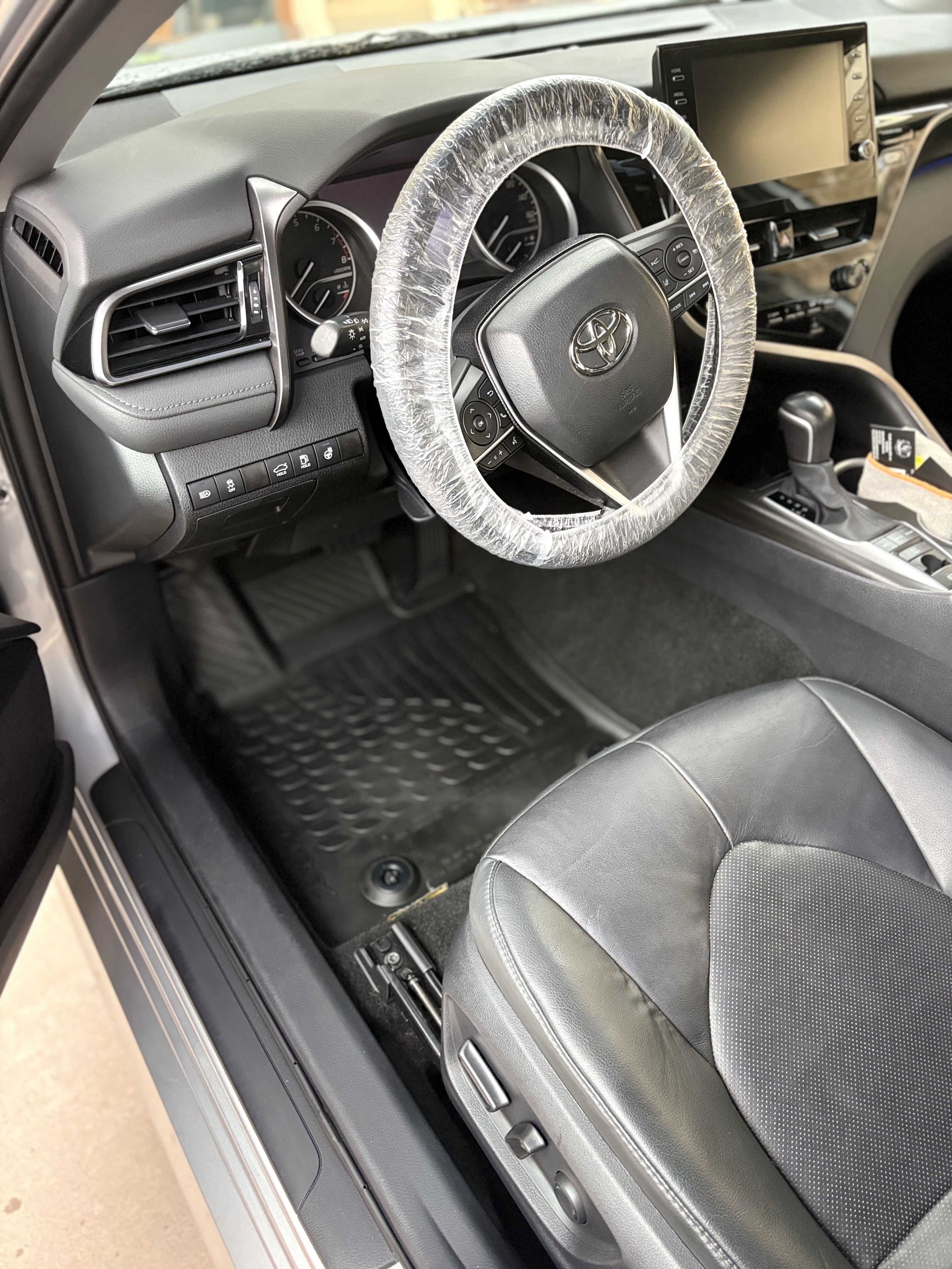 Toyota interior detailed with a protected steering wheel and fresh floor mats